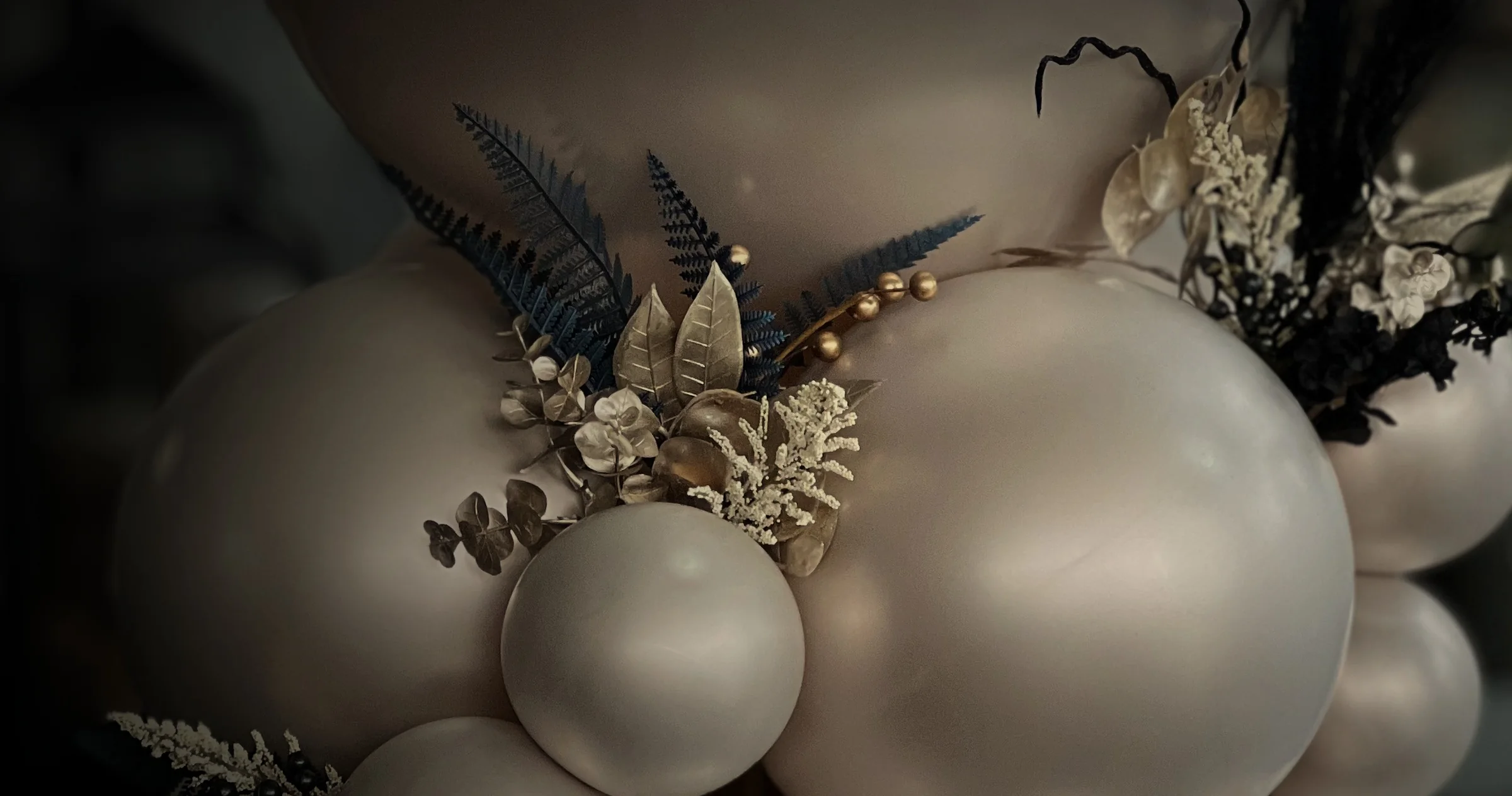 A sculptural arrangement of silver and black balloons creating an elevated celebration backdrop
